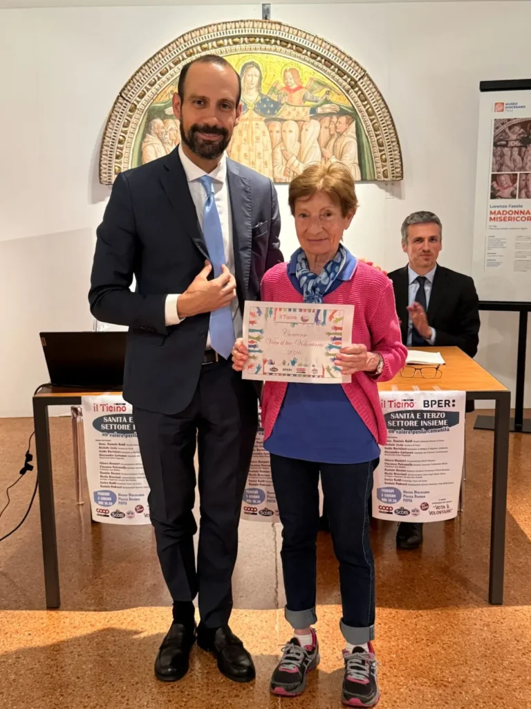 La Presidente del Circolo Logudoro Paola Pisano mostra l'attestato del concorso Vota il tuo Volontario, premiata dal Sindaco di Pavia Michele Lissia al Museo Diocesano.